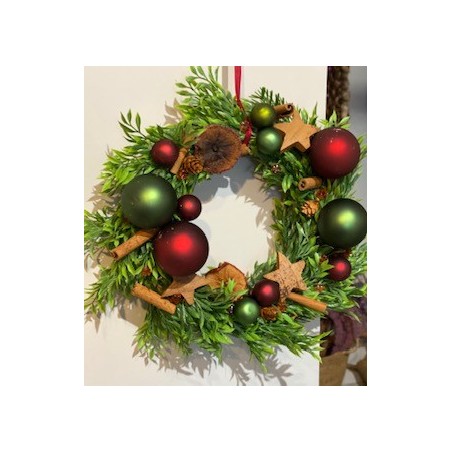 Corona navideña con tonos rojos y verdes.